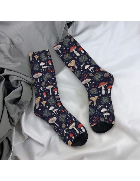 Calcetines negros con dibujos de hongos variados y puntos blancos, extendidos sobre una superficie de tela gris y blanca.